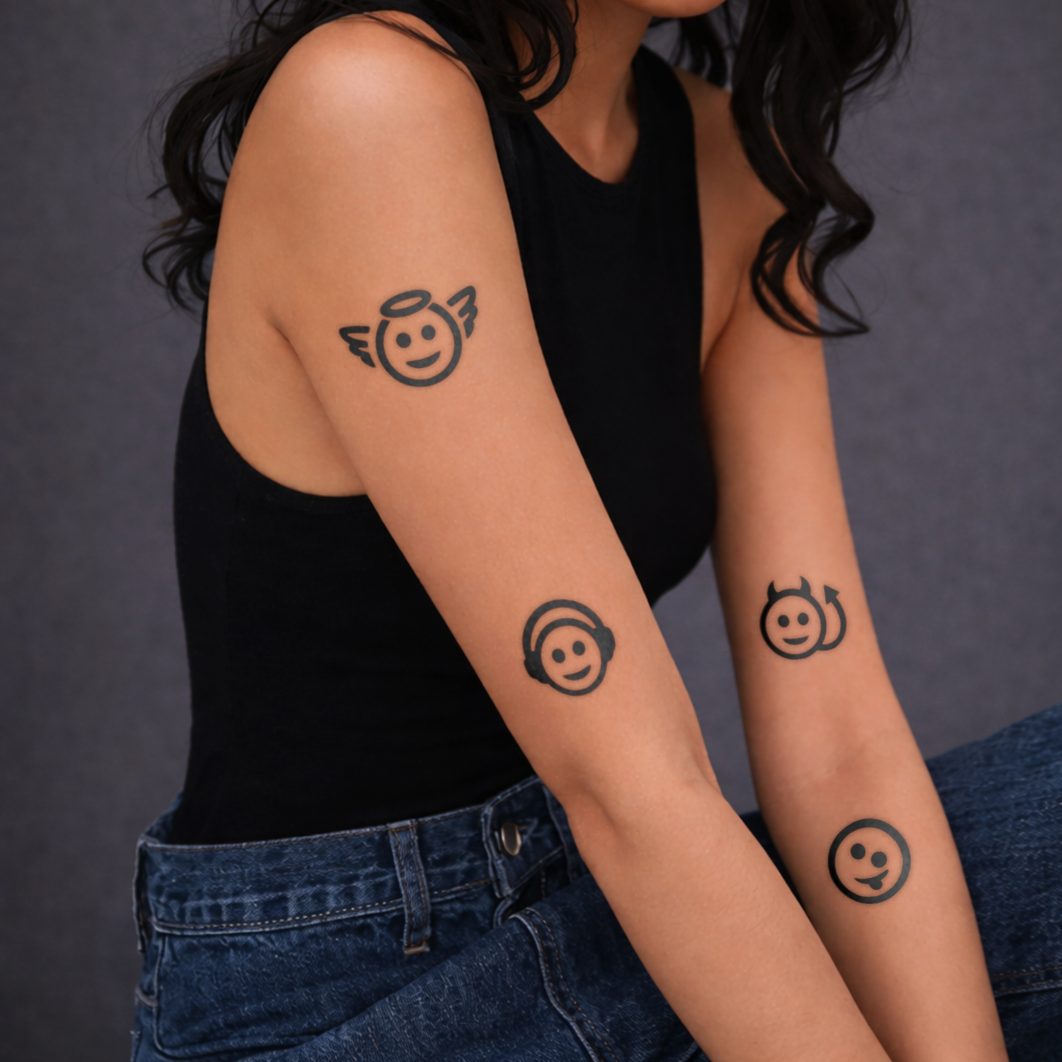 Person with temporary tattoos of smiley faces with different expressions on their arms.