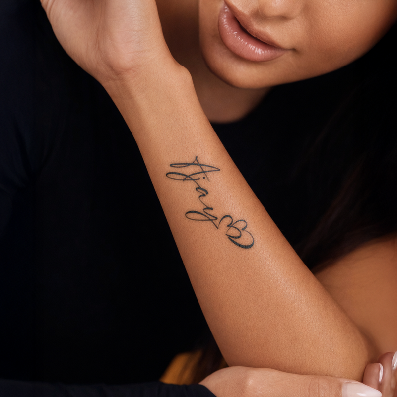 Person with a tattoo on their arm against a dark background