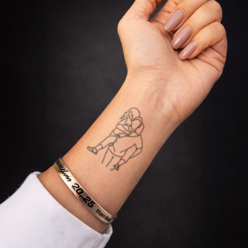Hand with a tattoo of a person sitting on a globe, wearing a bracelet with numbers on a dark background