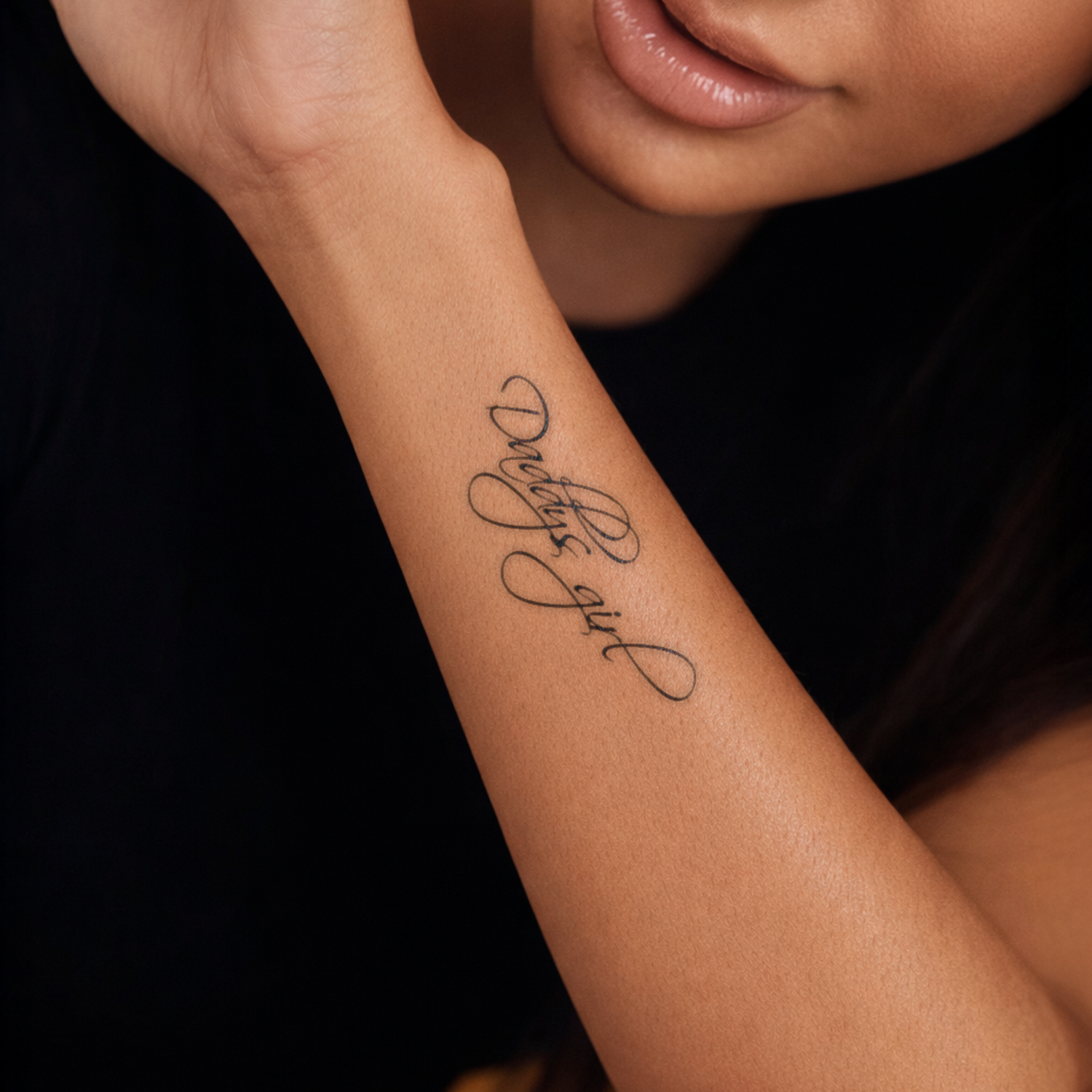Tattoo on a person's arm with the text 'Delfina girl' against a dark background
