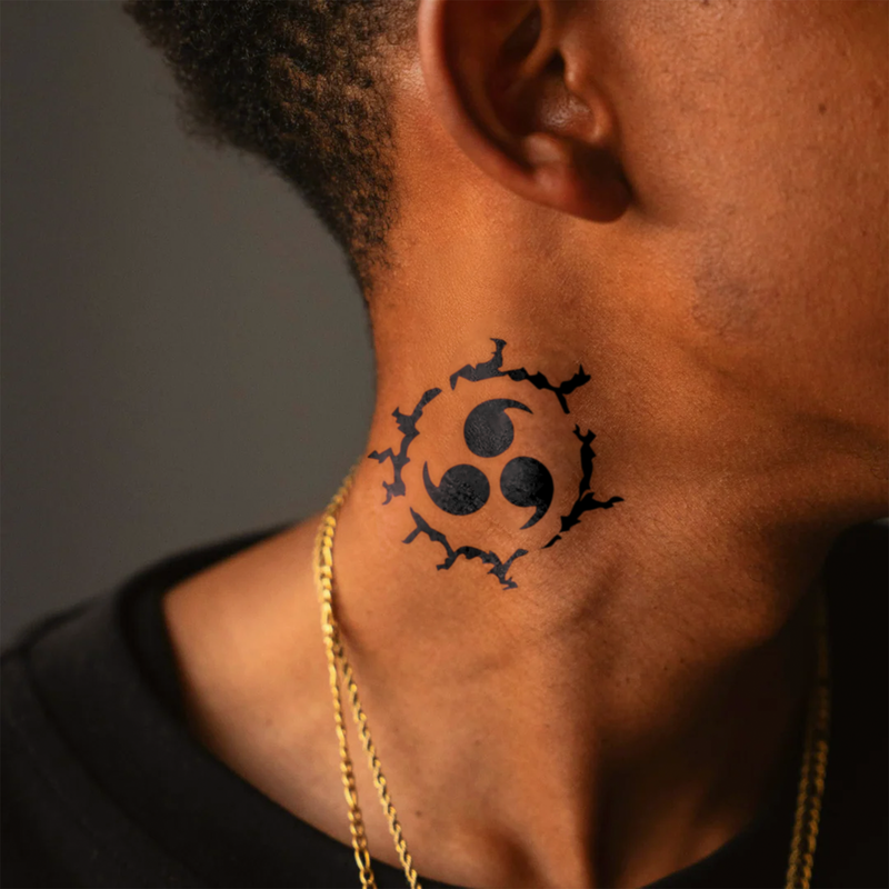 Black tattoo on a person's neck with a gold chain visible