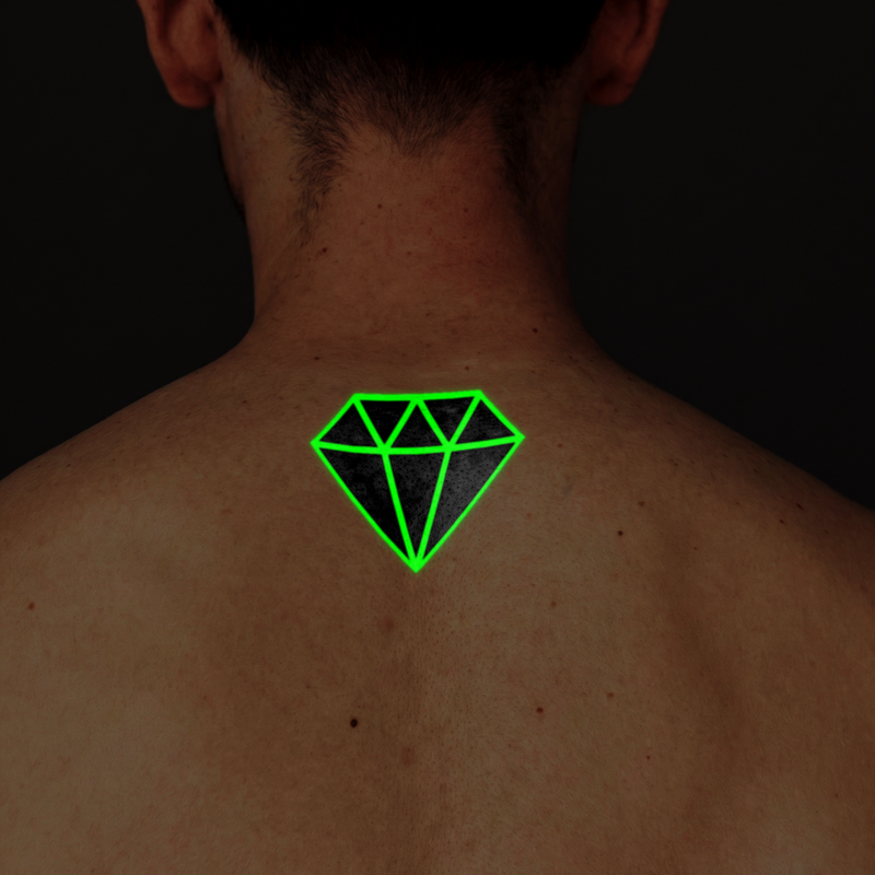 Green diamond-shaped tattoo on a person's back against a dark background