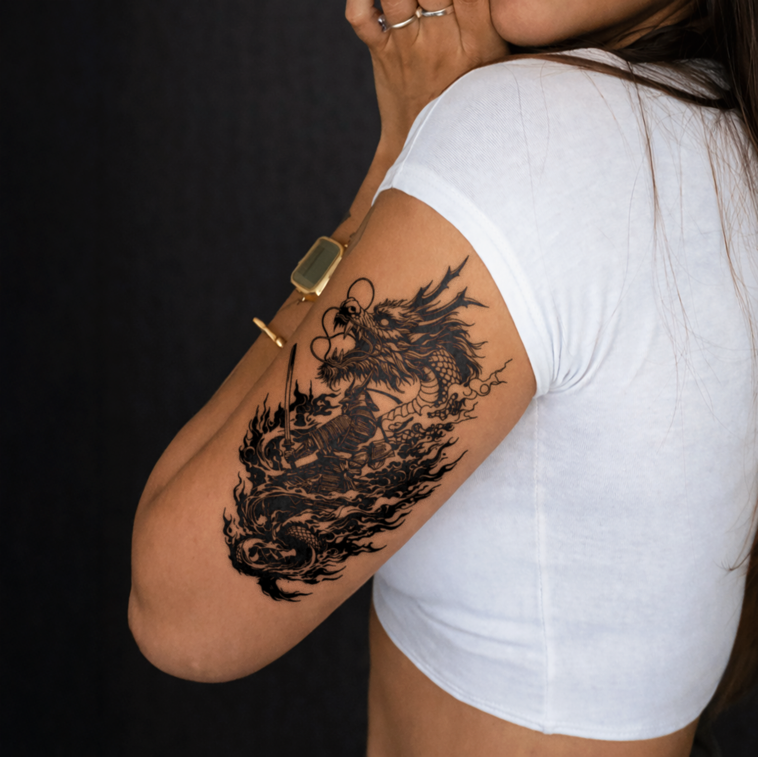 Person wearing a white t-shirt with a black dragon tattoo on their arm against a dark background