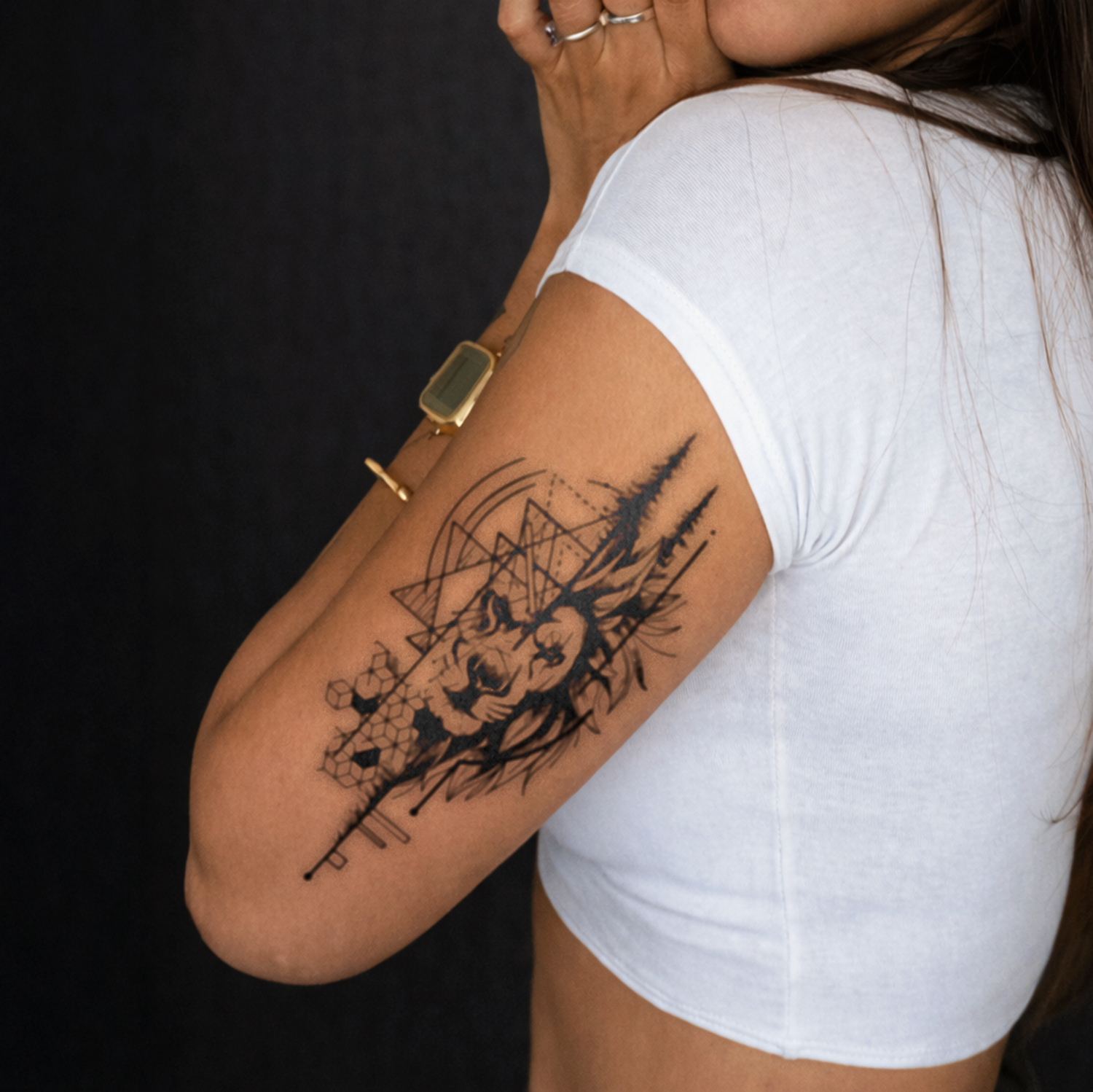 Person wearing a white t-shirt with a black tattoo on their arm against a dark background