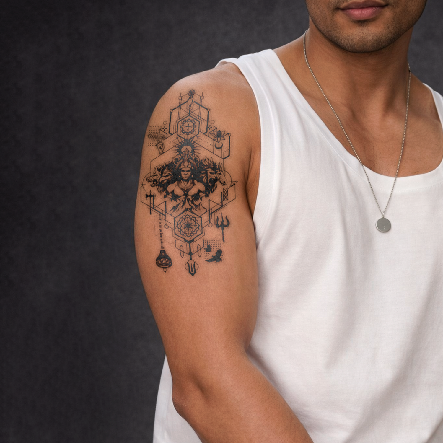 Man wearing a white tank top with a geometric tattoo on his arm against a dark background