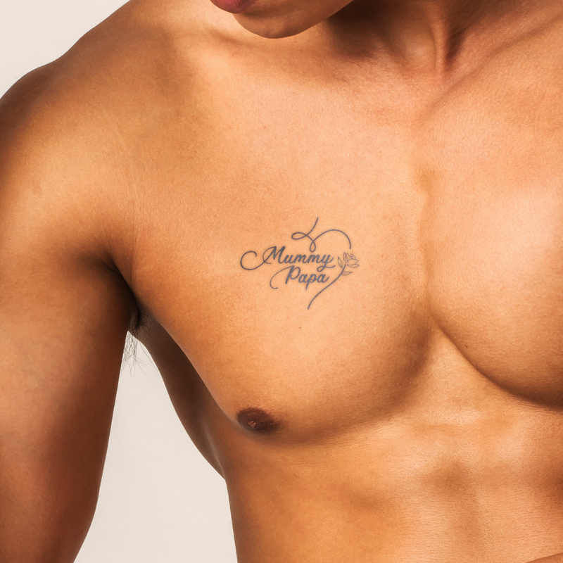 Tattoo on a person's chest with 'Mummy Papa' and a heart design.