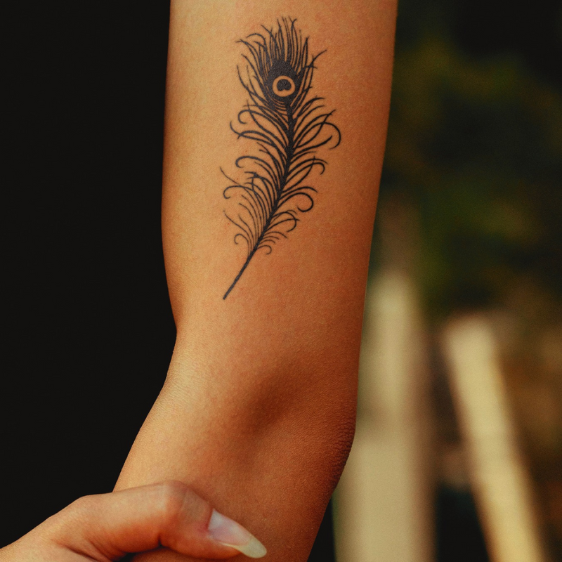 Peacock feather tattoo on a women left arm 
