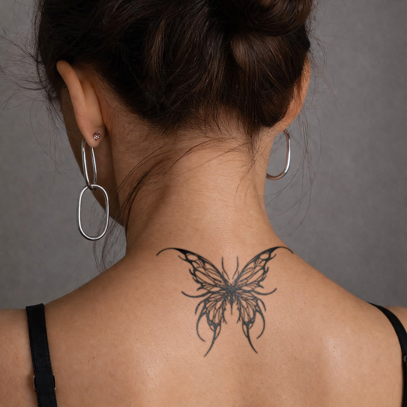 Woman with a butterfly tattoo on her neck against a gray background