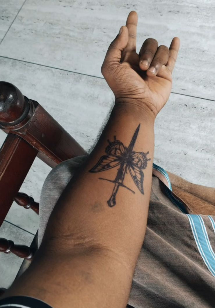 Person's arm with a tattoo on a tiled floor background