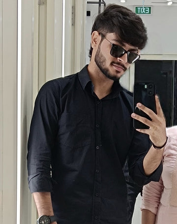 Two people taking a mirror selfie in a store.